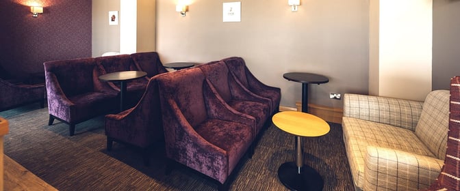 Booth seating in the Aspire Lounge at Inverness Airport provides semi-private spaces with small tables for passenger comfort and convenience.