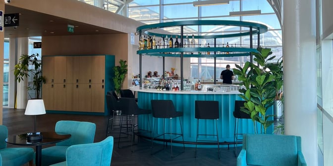 The Primeclass Lounge at Izmir Airport features a circular bar with seating, offering a selection of beverages and snacks.