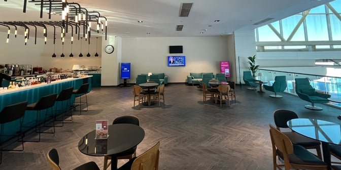 The Primeclass Lounge at Izmir Airport features a bar with seating, a television, and various seating arrangements for relaxation.