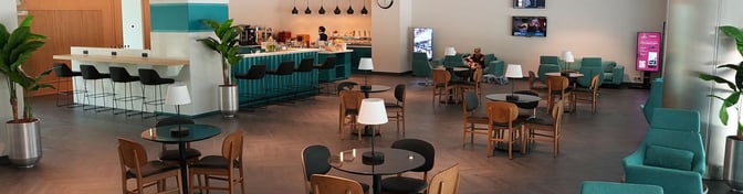 The Primeclass Lounge at Izmir Airport features a bar with counter seating and a dining area with tables and chairs.