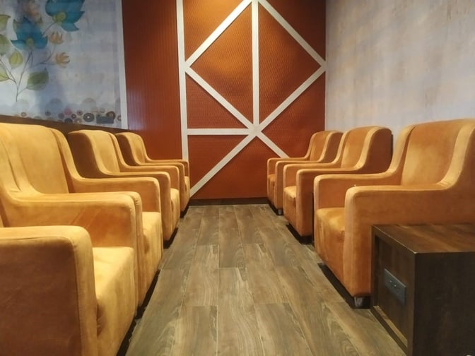 The seating area in Paahun The Executive Lounge at Jammu Airport features rows of comfortable chairs with adjacent side tables.