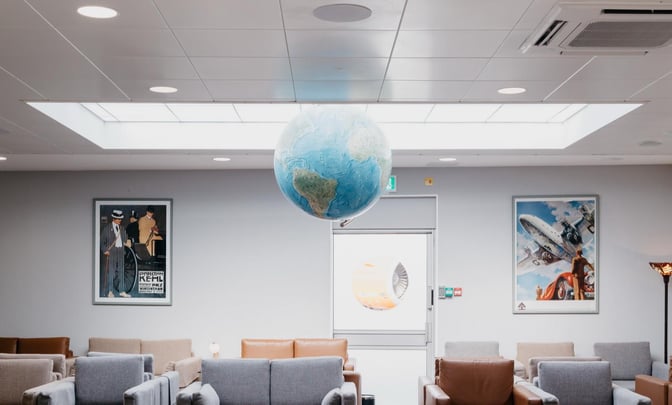 Seating area in the Executive Lounge at Jersey Airport features comfortable chairs and aviation-themed artwork, providing a relaxing space for travelers.
