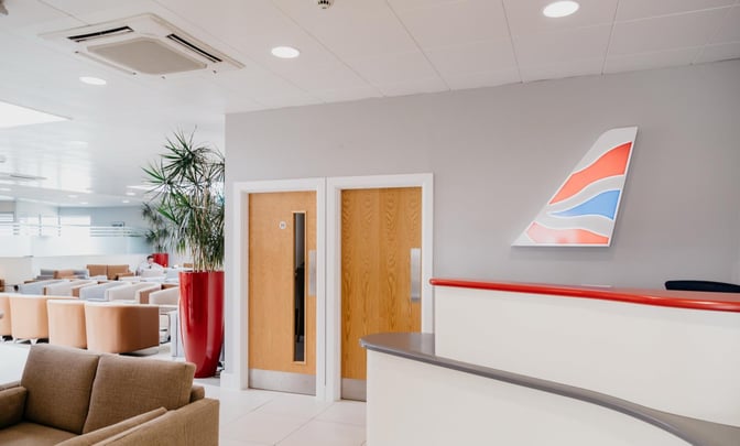 The Executive Lounge at Jersey Airport features a reception desk and a seating area with comfortable chairs for travelers.
