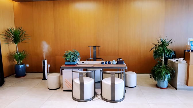 The seating area in First-Class Lounge No. 4 at Jinan Yaoqiang International Airport features a table with chairs and decorative plants.