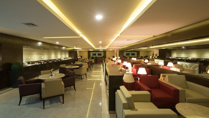 The marhaba Lounge at Jinnah International Airport features a seating area with tables and chairs, offering a comfortable waiting space.