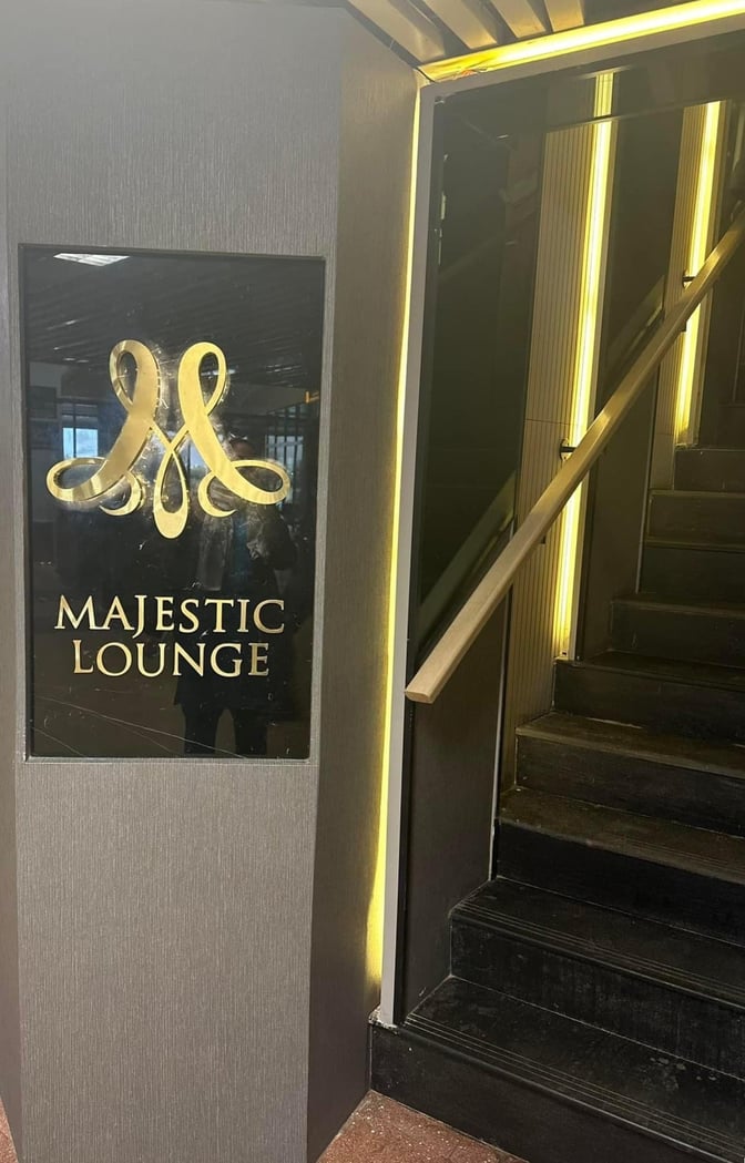 The entrance to the Sky Majestic Lounge at Jinnah International Airport features a sign and a staircase leading upwards.