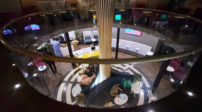 The Sky Majestic Lounge at Jinnah International Airport features a circular seating area with tables and a central column.