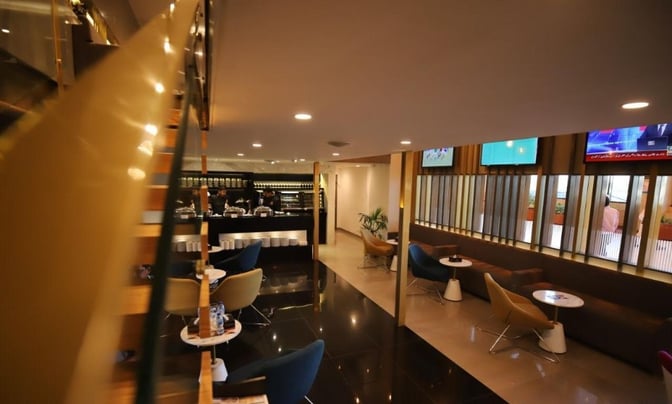 The Majestic Lounge at Jinnah International Airport features a bar area with counter seating and a seating area with tables and chairs.