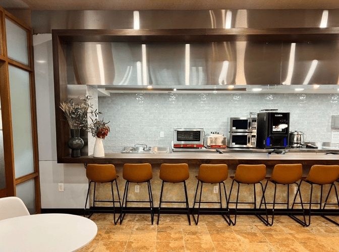 The VIP One lounge at JFK Airport features a counter seating area with self-serve kitchen appliances and a coffee machine.