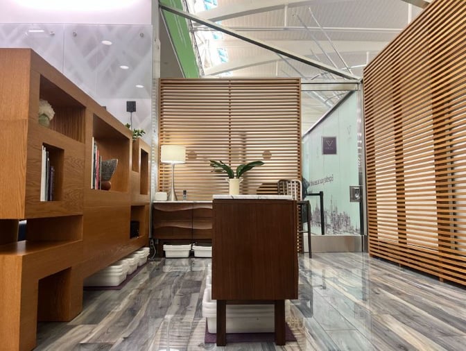 The VIP One Lounge at JFK Airport features a seating area with wooden partitions, a small table, and decorative shelving.