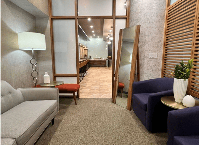 The VIP One lounge at JFK Airport features a cozy seating area with sofas and a view into the bar area.