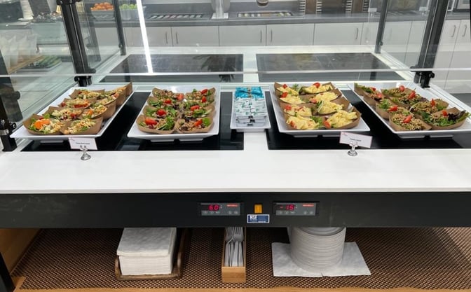 The HelloSky Lounge at JFK Airport offers a self-serve food station with a variety of prepared salads and condiments.
