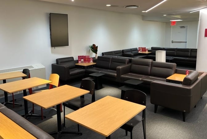 The HelloSky Lounge at JFK Airport features a seating area with sofas and tables, providing a comfortable space for travelers.