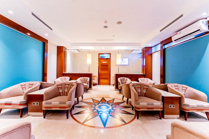 Seating area in Aspire Lounge at Jomo Kenyatta International Airport features comfortable chairs and tables, with power outlets available for travelers.