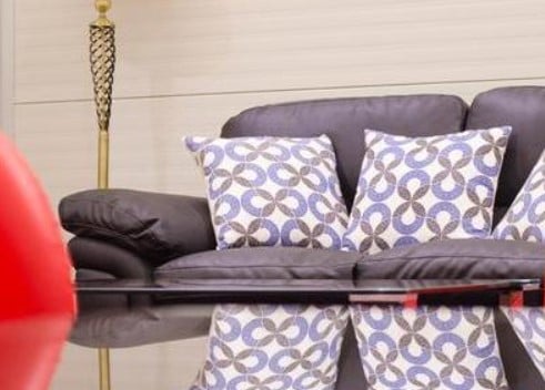 The seating area in Mount Kenya Lounge features a comfortable sofa with patterned cushions and a reflective coffee table.