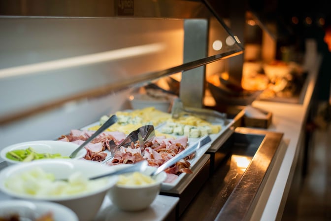 The AMAE Lounge at Aeroparque features a self-serve buffet with a selection of cold cuts, cheeses, and fresh vegetables.