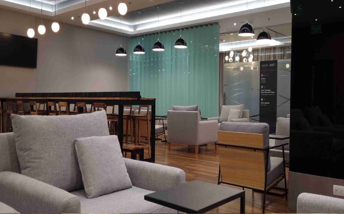 The AMAE Lounge at Aeroparque features comfortable seating with armchairs and tables, providing a relaxing space for travelers.