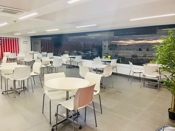 The Avianca Lounge at José María Córdova International Airport features a seating area with round tables and chairs, overlooking the tarmac.