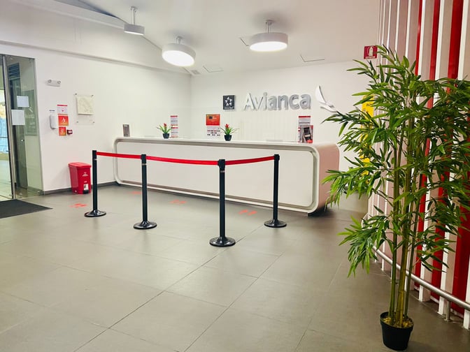The Avianca Lounge entrance at José María Córdova International Airport features a reception desk with a barrier and informational signage.