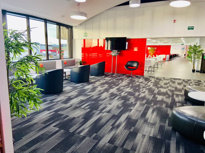 The Avianca Lounge at José María Córdova International Airport features seating areas with armchairs and tables, adjacent to a dining section.