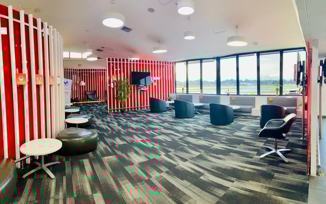 The Avianca Lounge at José María Córdova International Airport features seating areas with tables and chairs, offering views of the runway.