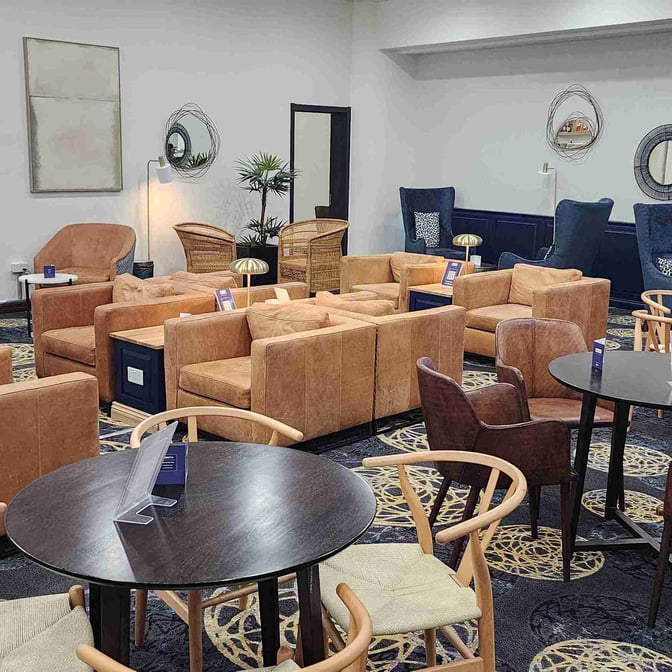 The seating area at Khami Lounge features comfortable armchairs and tables, providing a relaxing space for travelers at Joshua Mqabuko Nkomo International Airport.