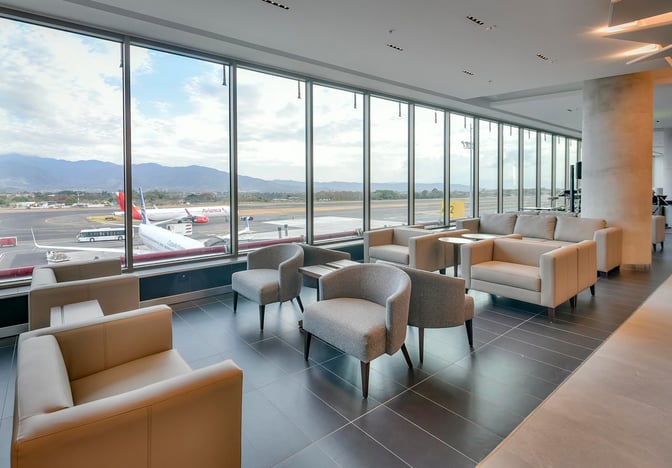 The seating area in the BAC Credomatic Lounge at Juan Santamaría International Airport offers comfortable chairs with expansive views of the runway.