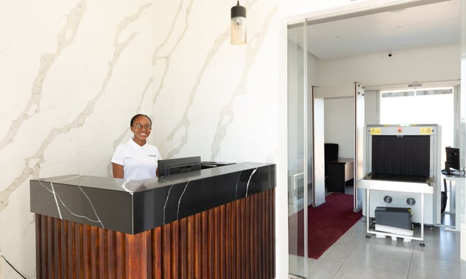 The Serengeti Lounge entrance at Julius Nyerere International Airport features a reception desk and security screening area.