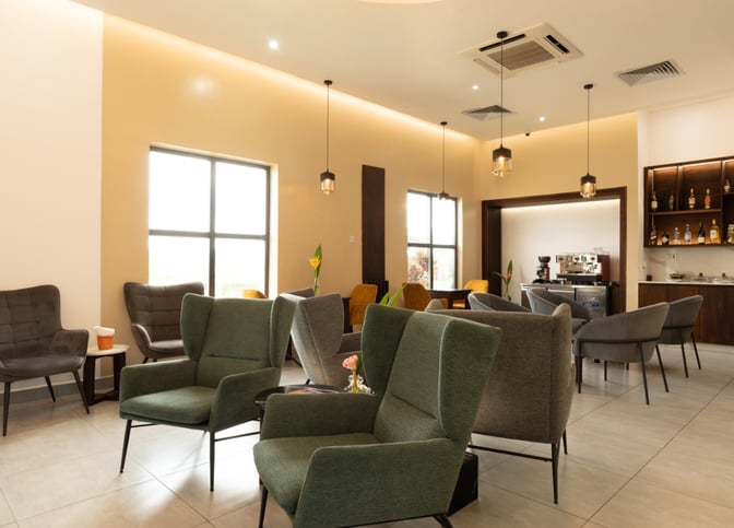 The Serengeti Lounge at Julius Nyerere International Airport features comfortable seating with a bar area offering various beverages.
