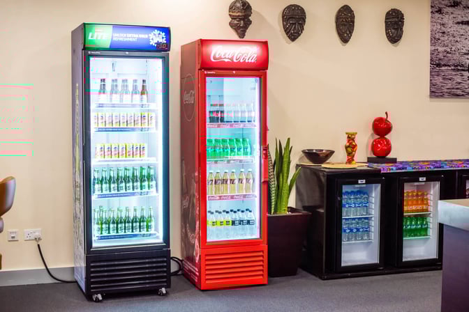 The beverage area at Twiga Lounge features self-serve coolers stocked with assorted drinks, including sodas and bottled water.