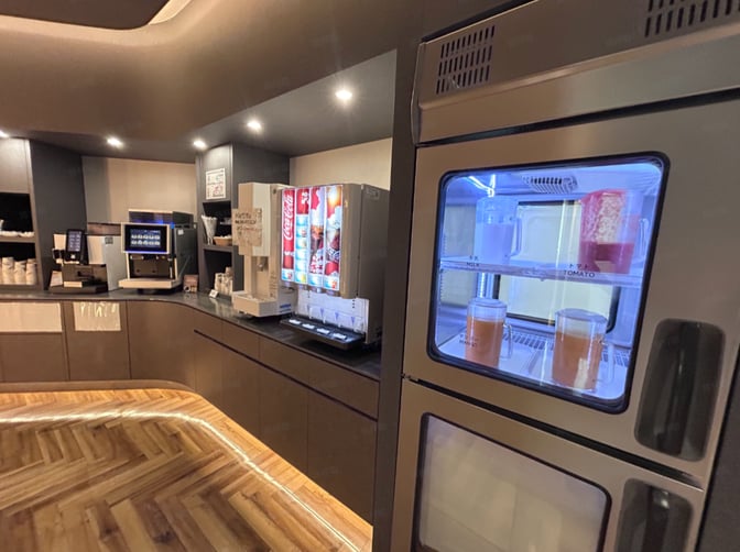 The SKY Lounge at Kagoshima Airport features a beverage station with self-serve soda dispensers, coffee machines, and refrigerated juice options.