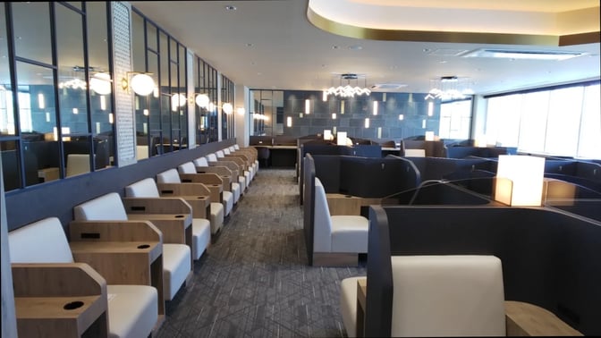 The SKY Lounge at Kagoshima Airport features individual seating pods with armrests and tables, providing a semi-private space for travelers.