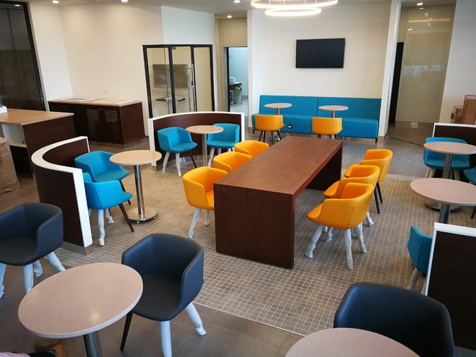 The seating area at Pearl Lounge, Kannur International Airport, features various chairs and tables for passenger comfort and relaxation.