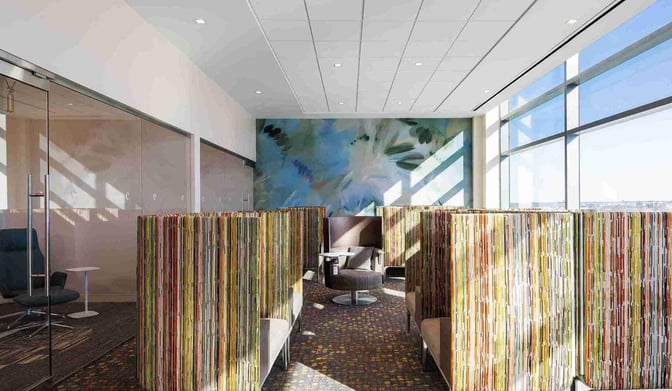 Booth seating in the Escape Lounge at Kansas City International Airport offers semi-private spaces with views through large windows.