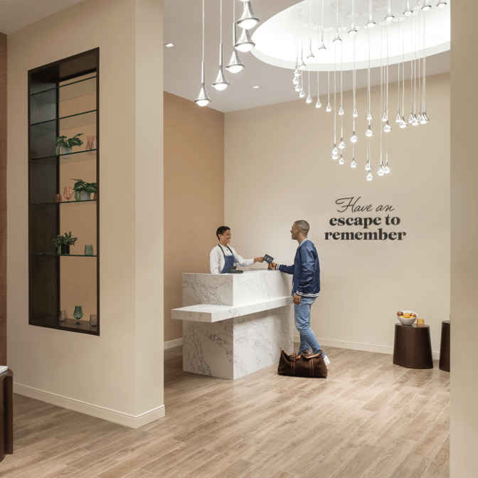 The reception area of the Escape Lounge at Kansas City International Airport features a check-in counter and welcoming staff.