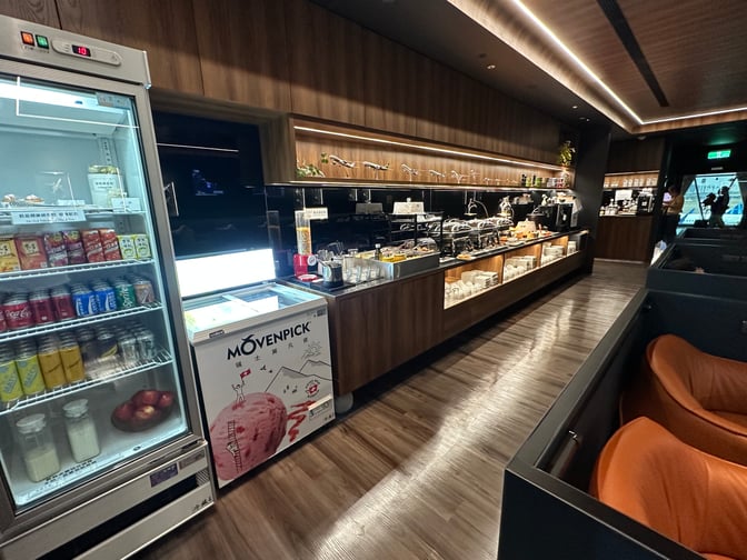 The Southern Premium Lounge at Kaohsiung International Airport features a self-serve food and beverage area with refrigerated drinks and snacks.