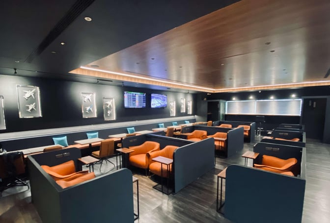 Semi-private seating areas in the Southern Premium Lounge at Kaohsiung International Airport offer individual tables and chairs for travelers.