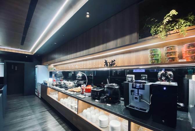 The Southern Premium Lounge at Kaohsiung International Airport features a self-serve food area with hot dishes, snacks, and a coffee machine.
