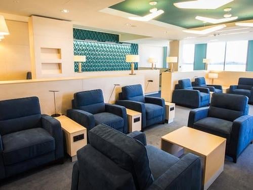 Seating area in Katowice International Airport's Business Lounge features comfortable armchairs and tables, providing a relaxing space for travelers.