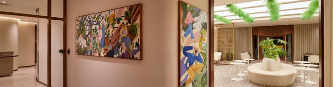 The 080 Arrivals Lounge at Kempegowda Bangalore International Airport features a seating area with round tables and decorative artwork.