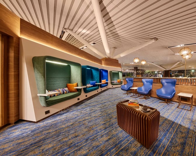 The lounge at Kempegowda Bangalore International Airport features semi-private seating pods and comfortable chairs for relaxation and work.