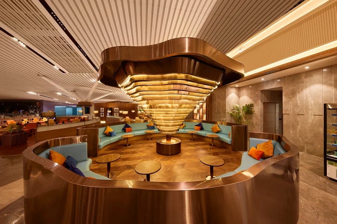 The seating area in the 080 Domestic Lounge at Kempegowda Bangalore International Airport features circular booths and small tables.