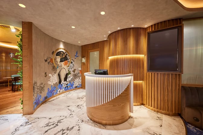 The reception area of the 080 Domestic Lounge at Kempegowda Bangalore International Airport features a curved desk and decorative wall art.