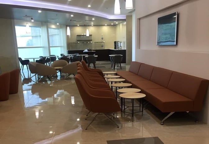 The seating area in Pearl Lounge Zambia features rows of chairs and tables, with a view of the dining section.