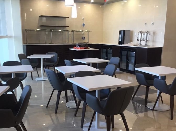 The dining area at Pearl Lounge Zambia features tables and chairs with a self-serve counter for refreshments and snacks.