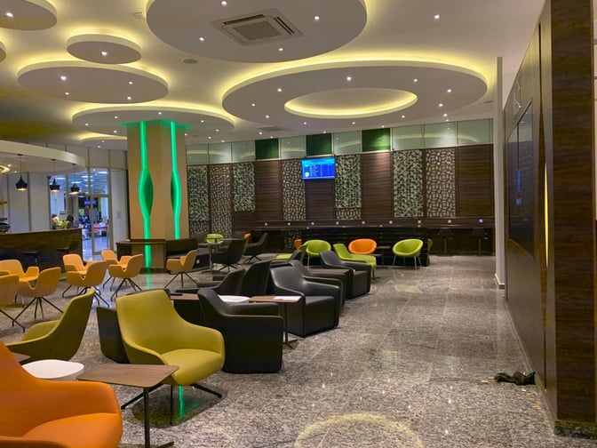 The Pearl Departures Lounge at Kigali International Airport features diverse seating options with tables, ideal for relaxation and work before flights.