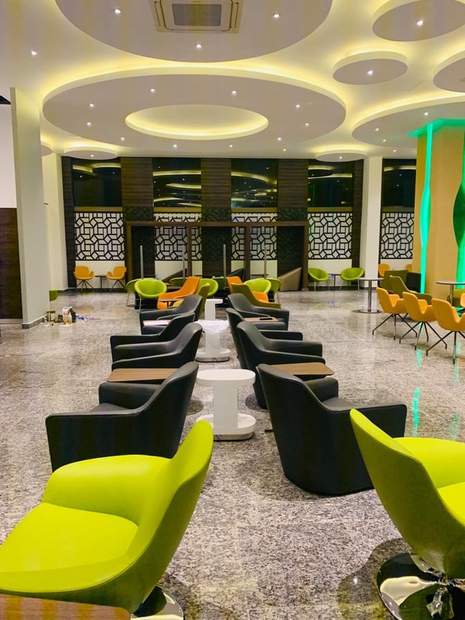 The Pearl Departures Lounge at Kigali International Airport features a spacious seating area with armchairs and small tables for travelers.