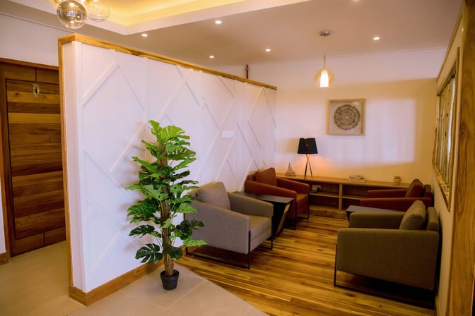 The seating area at Twiga Lounge, Kilimanjaro International Airport, features comfortable armchairs and a side table with a decorative lamp.