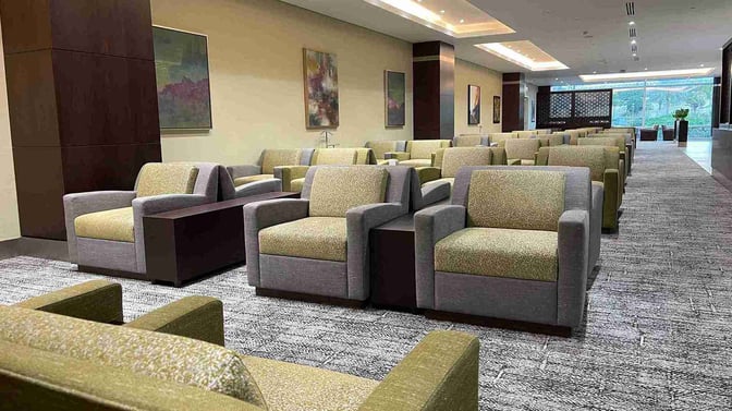 The seating area in Flynas Lounge at King Abdulaziz International Airport features rows of armchairs with side tables for passenger comfort.