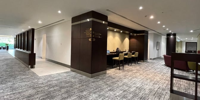 The Flynas Lounge at King Abdulaziz International Airport features a seating area with bar-height chairs and workstations for travelers.